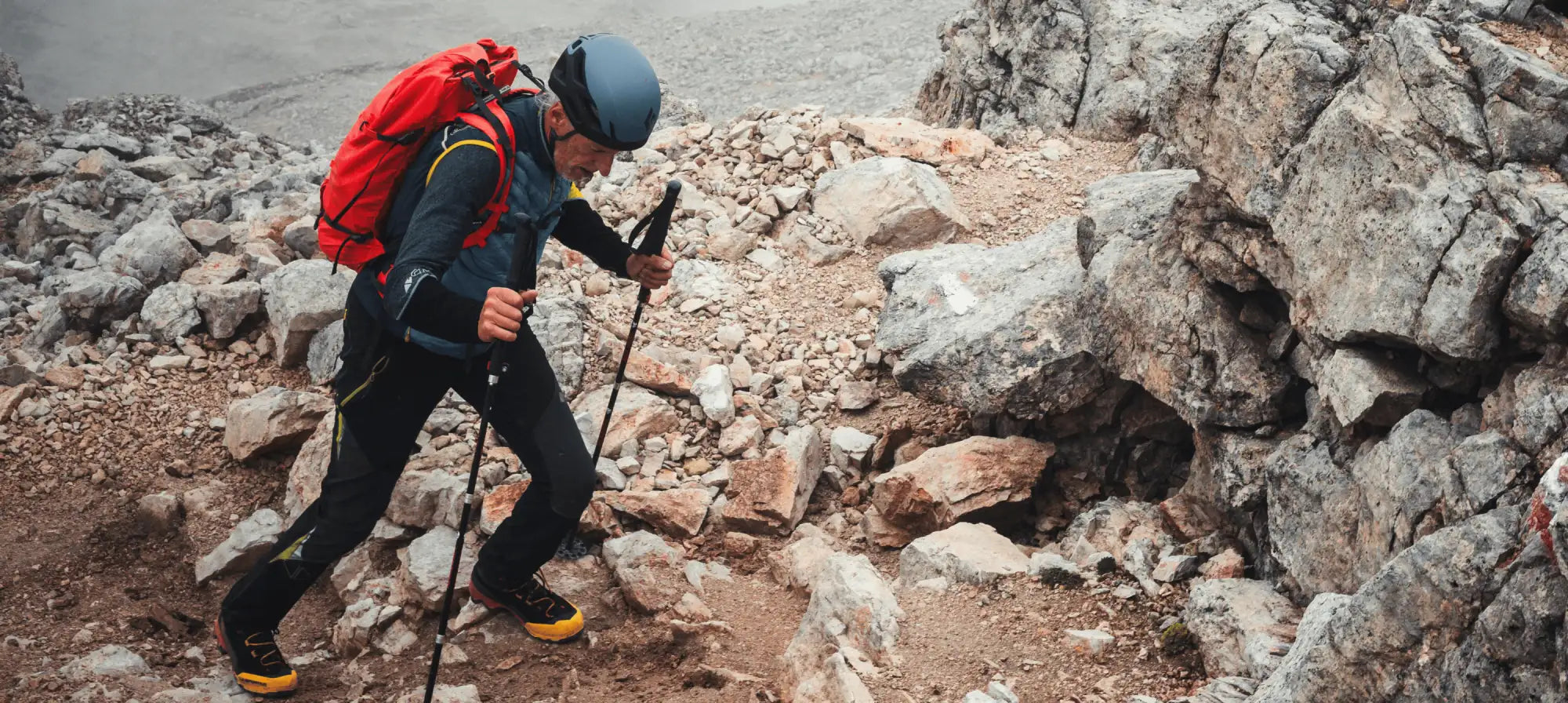 Red backpack with black straps and yellow accents, made of durable nylon material.